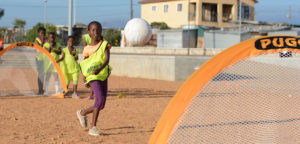 Girl in Africa shooting on a Pugg soccer gaol - Grassroots Soccer and Pugg partnership image